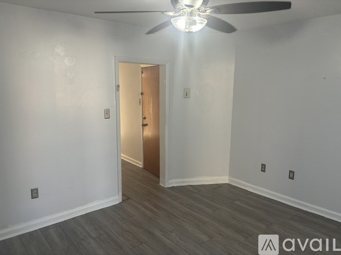 A room with a ceiling fan and a door.