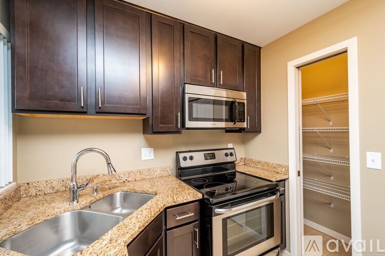 A kitchen with brown cabinets and a black stove top oven.
