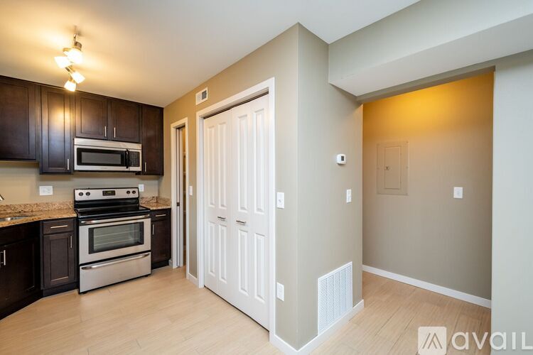 A kitchen with dark brown cabinets and a white door.