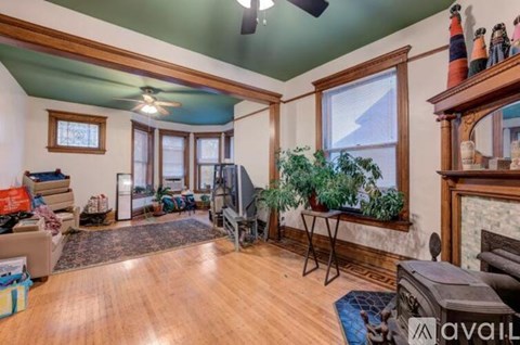 A living room with a fireplace and a ceiling fan.