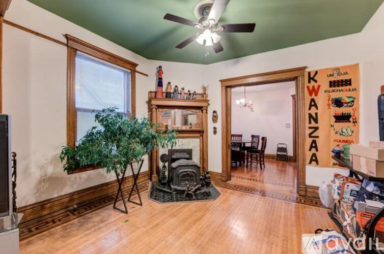 A room with a fireplace and a tree in a pot.