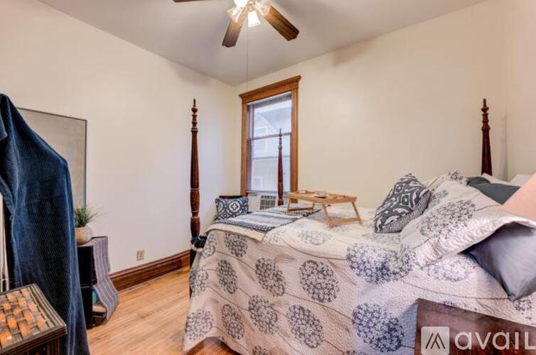 A bedroom with a bed, a window, and a ceiling fan.