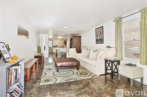 A living room with a white couch and a rug.