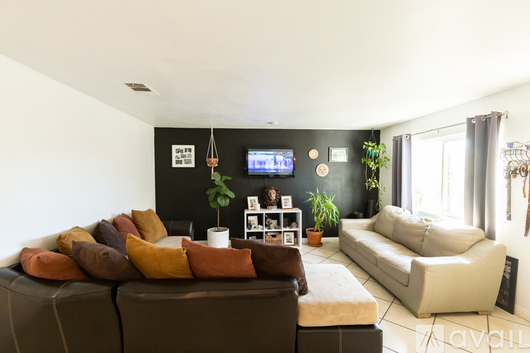 A living room with a brown couch and a white sofa.
