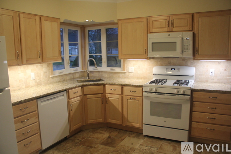 A kitchen with wooden cabinets and a white dishwasher.