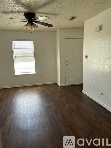 A room with a ceiling fan and a window.