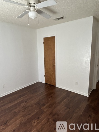 A room with a wooden door and a ceiling fan.