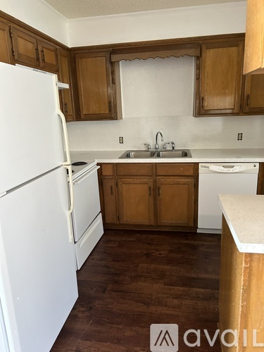 A kitchen with wooden cabinets and a white refrigerator.