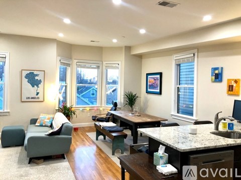 A living room with a couch, a table, and a window.