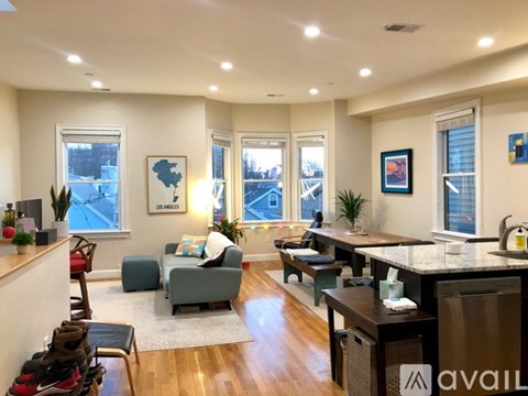 A well-lit living room with a kitchen area in the background.