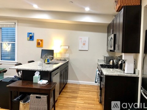 A kitchen with a table and a fridge.