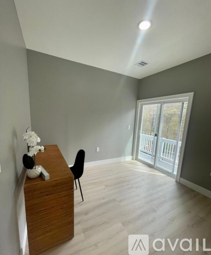 A room with a wooden dresser and a black chair.