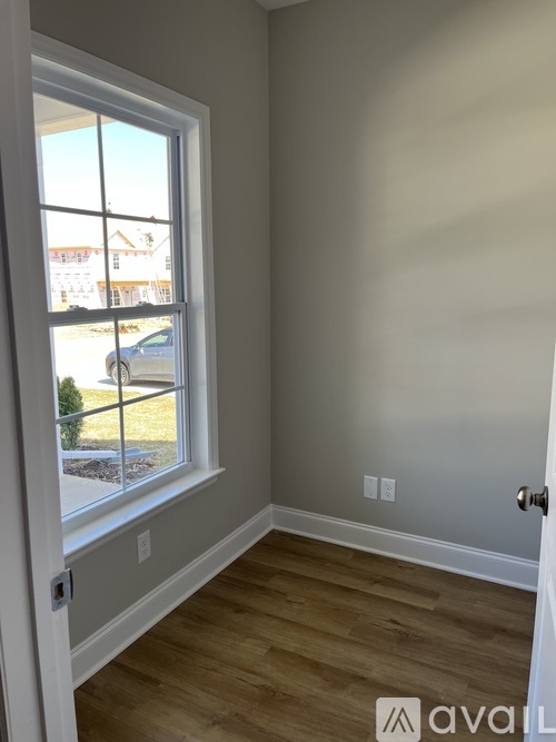 A room with a window and wooden flooring.