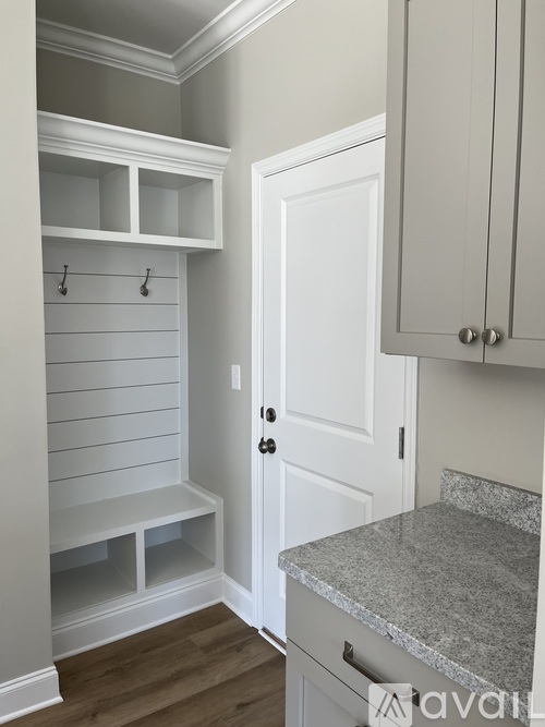 A kitchen with white cabinets and a marble countertop.