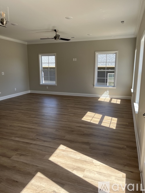 A room with wooden floors and a ceiling fan.