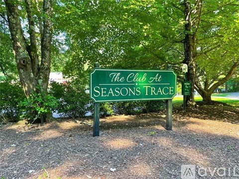 A green sign that says "The Club at Seasons Trace" is in front of some trees.