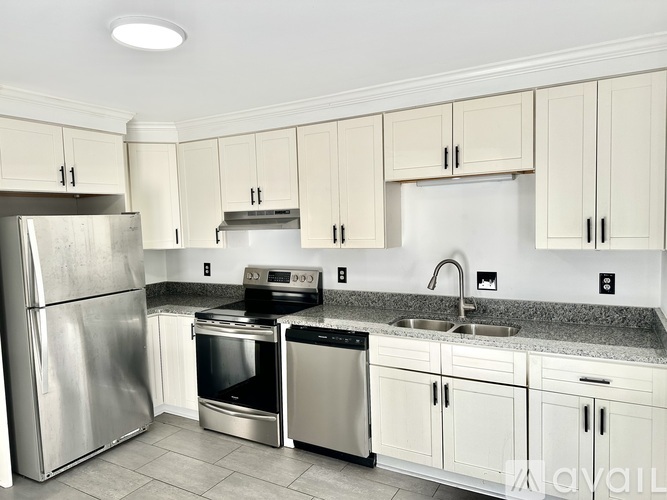 A kitchen with white cabinets and stainless steel appliances.