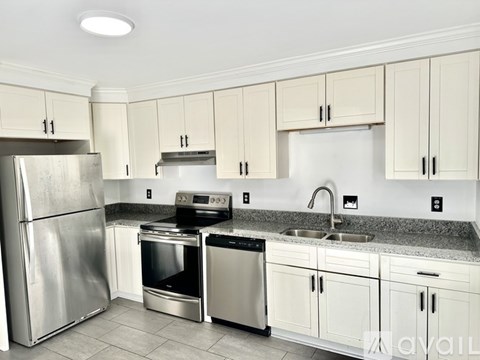 A kitchen with white cabinets and stainless steel appliances.