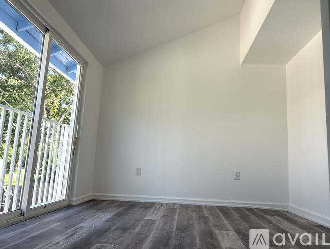 A room with a sliding glass door leading to a balcony.