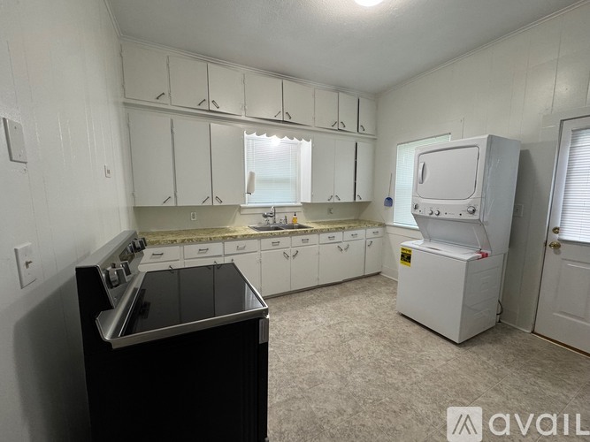 A kitchen with white cabinets and a black stove top oven.