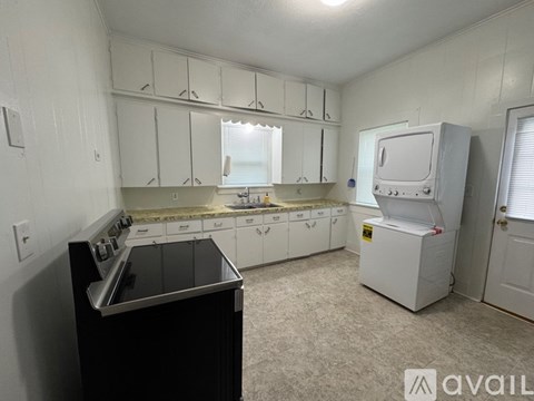 A kitchen with white cabinets and a black stove top oven.