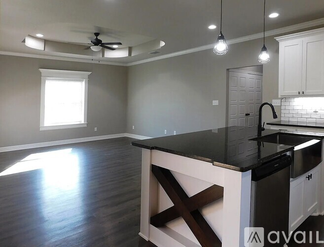 A kitchen with a black countertop and white cabinets.