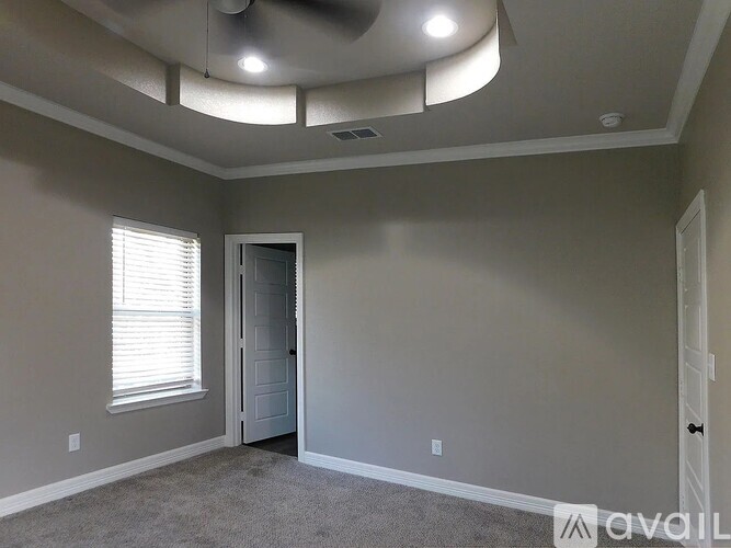 A room with a ceiling fan and a door.