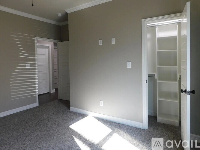 A room with a carpeted floor and a white door.