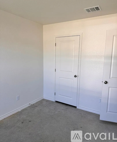 A room with a white door and a white wall.