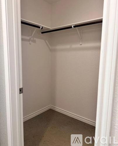 A small, empty closet with a white door and a white curtain.