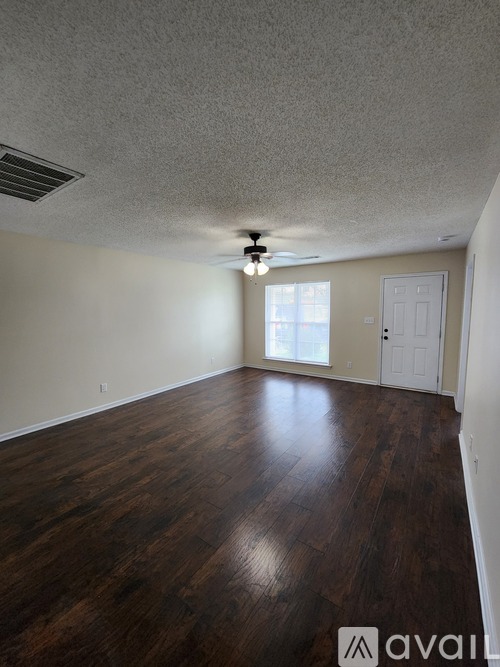 A room with wooden floors and a ceiling fan.