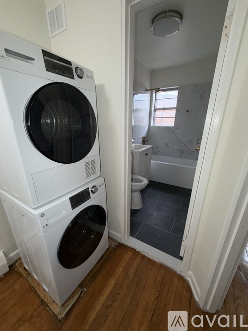 A white front loading washing machine in a laundry room.