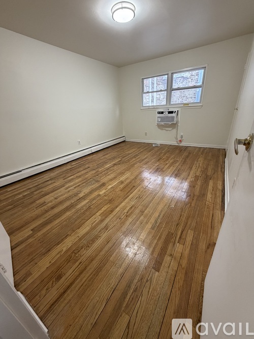 A room with wooden flooring and a window.