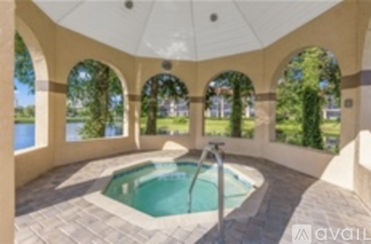 A round pool with a hot tub in the middle of a patio with a white canopy.