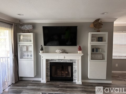 A living room with a fireplace and a television mounted on the wall.