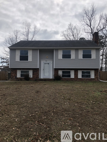 A house with a grey siding and a white door is shown.