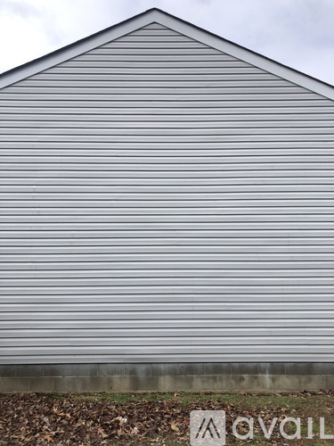 A grey building with a sign that says "avail" in front of it.