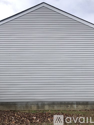 A grey building with a sign that says "avail" in front of it.