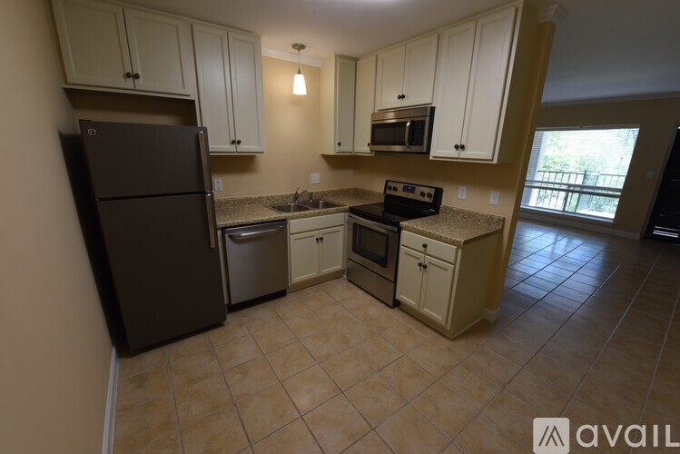 A kitchen with a refrigerator, microwave, oven, and sink.