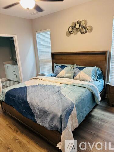 A bedroom with a bed covered in a blue and white comforter.