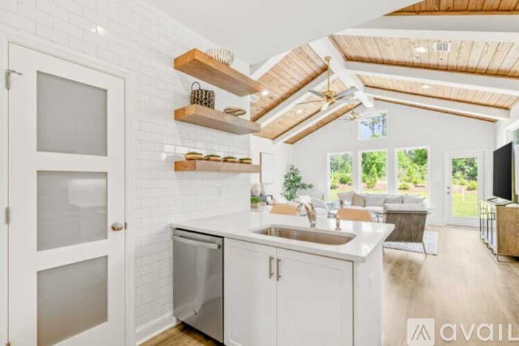 A kitchen with white cabinets and a white door.