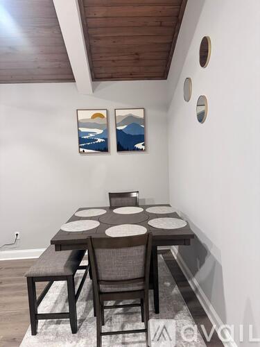 A dining room with a table and chairs.