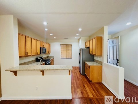 A kitchen with wooden cabinets and a granite countertop.