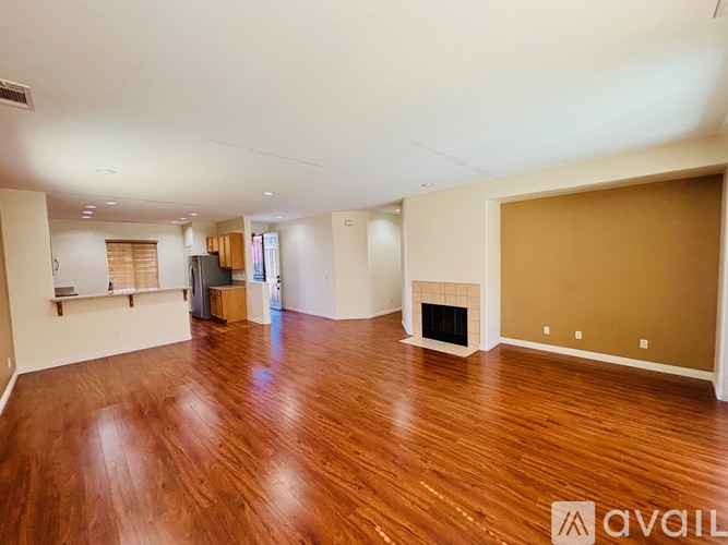 A spacious living room with hardwood floors and a fireplace.