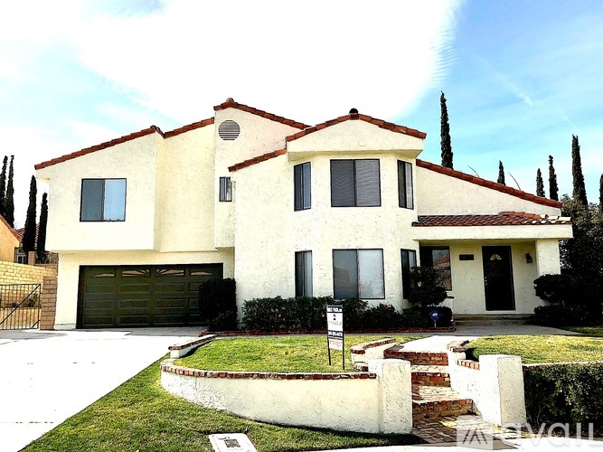 A two-story house with a garage and a driveway.