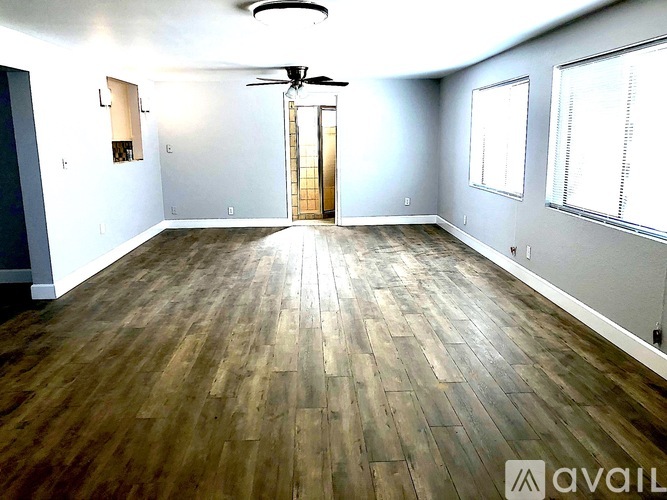 A room with wooden flooring and a ceiling fan.