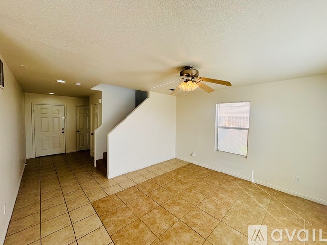 A room with a ceiling fan and tiled flooring.