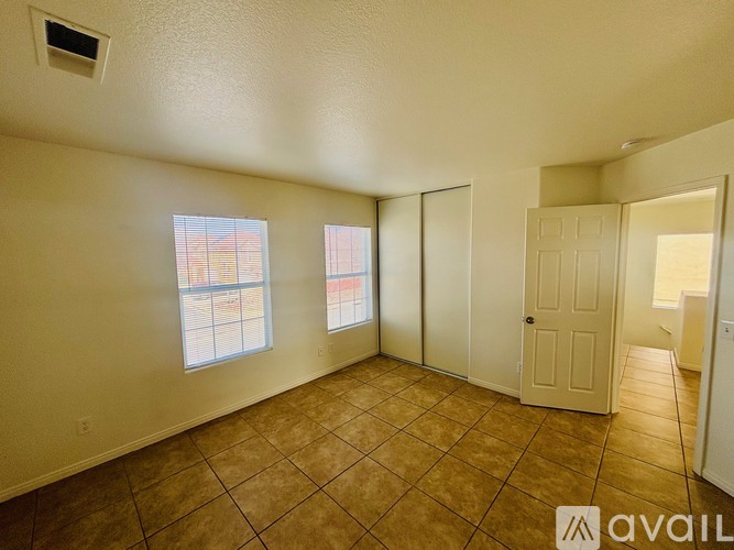 A room with tiled flooring and a window overlooking a building.