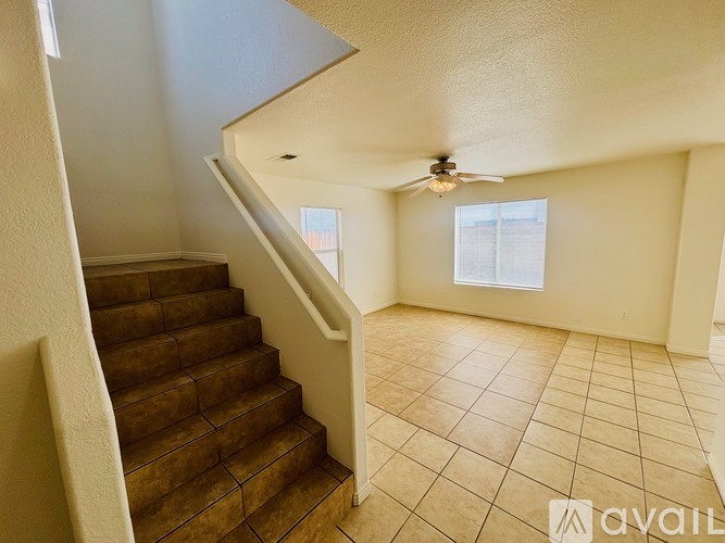 A room with a staircase and a ceiling fan.