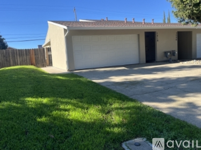 A house with a garage and a fence in the front yard.